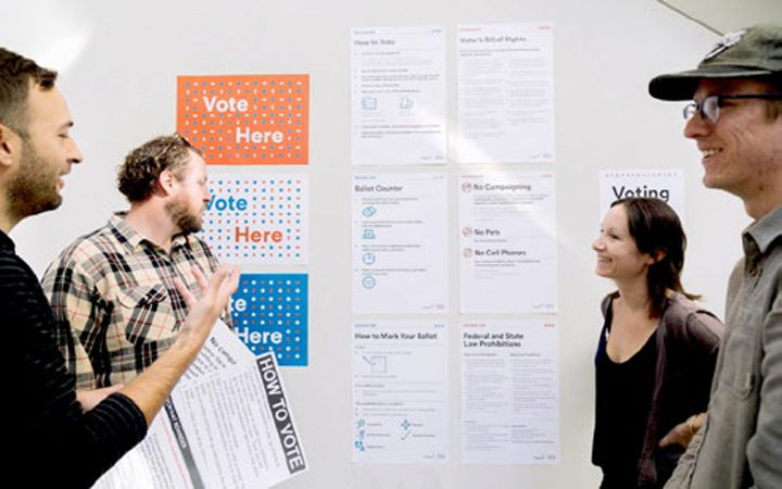 Photo of students talking in front of new signs on wall