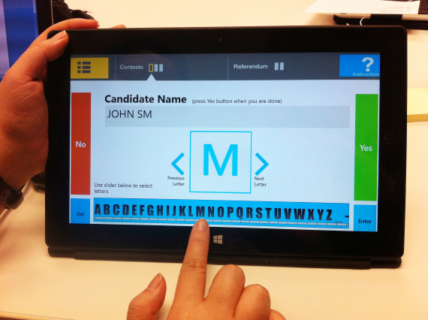 A tablet voting system. A voter is entering a write-in name using a slider control